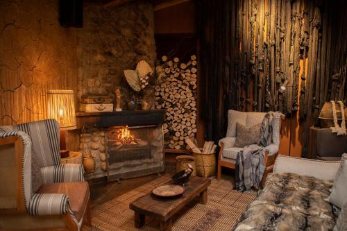 a living room with a fireplace and a couch and chairs at Cuesta Serena Boutique Hotel in Huaraz