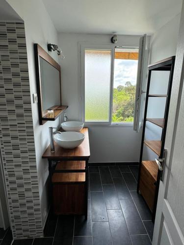une salle de bain avec deux lavabos et une fenêtre dans l'établissement Les hyacinthes 6, à Sarlat-la-Canéda