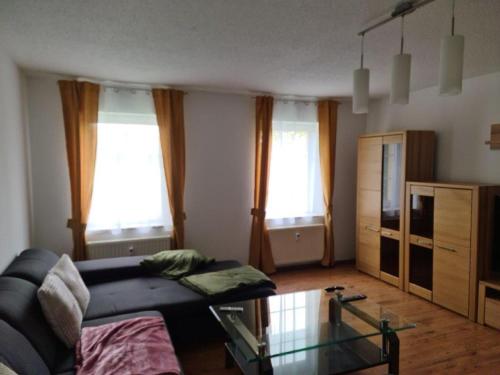 a living room with a couch and a glass table at Ferienwohnung II, Schloßstraße Kottmarsdorf in Kottmarsdorf