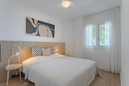 Habitación blanca con cama y ventana en Panoramic view apartment in Los Gigantes, en Acantilado de los Gigantes