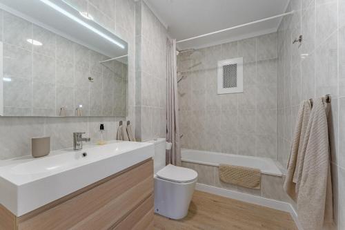 een badkamer met een wastafel, een bad en een toilet bij Panoramic view apartment in Los Gigantes in Acantilado de los Gigantes