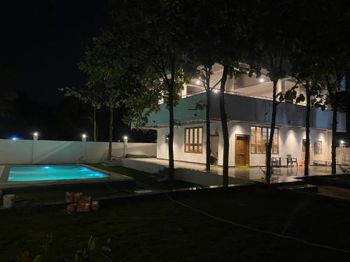 a house with a swimming pool at night at Dlr Tranquilla in Hyderabad
