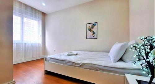 1 dormitorio con 1 cama con sábanas blancas y ventana en Mükemmel konum en Antalya