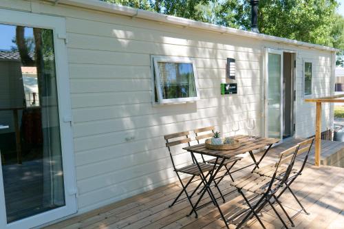 eine Terrasse mit Tisch und Stühlen auf einem Deck in der Unterkunft Vakantiehuis Hoge Kempen - 25 minuten Roermond, Maasmechelen & Maastricht in Kinrooi