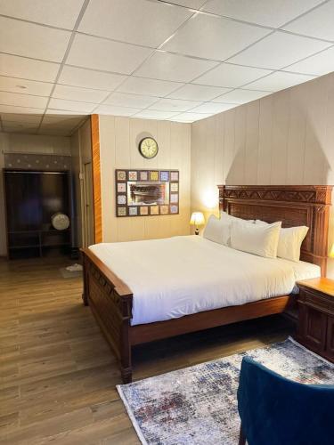 1 dormitorio con 1 cama grande y reloj en la pared en Infinity Villa and Resort Kumrat Valley, en Tāl