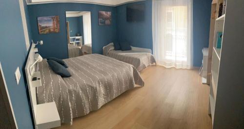 a bedroom with two beds and blue walls at Room 10 in Taranto