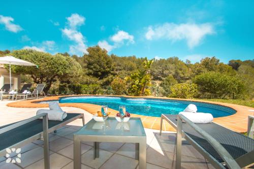 a swimming pool with a table and chairs next to a patio at Villa El Magraner by Abahana Villas in Benissa