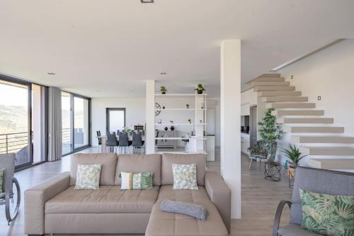 a living room with a couch and a staircase at Feel Discovery Alvim's Douro in Folgosa