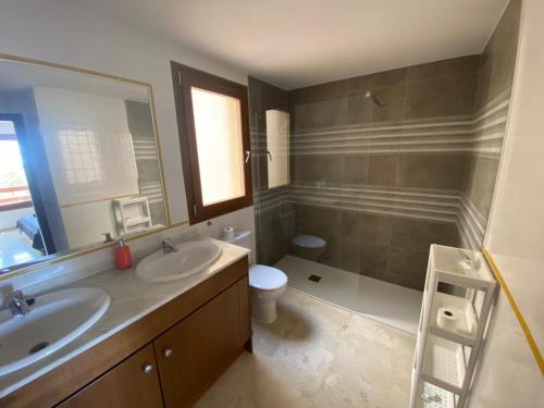 un bagno con due lavandini, una doccia e un WC di Apartamento con piscina y playa cercana en Torrevieja, area de Punta Prima AQ-125 a Punta Prima