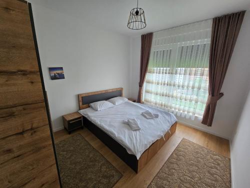 - une chambre avec un lit, une fenêtre et un miroir dans l'établissement Dardania 2 Kastrati, à Prizren