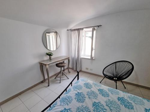 1 dormitorio con cama, escritorio y espejo en Maridea - Via Dragonara, en Ponza