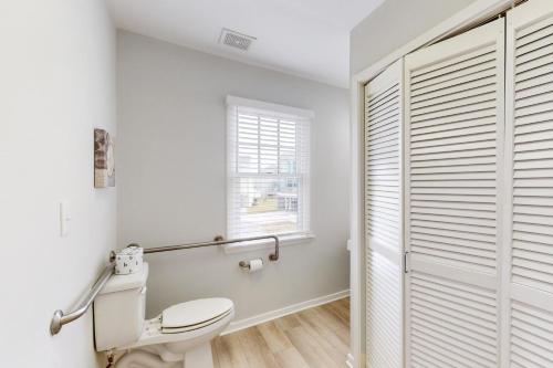 a white bathroom with a toilet and a window at Striper #20A-CAC in Buxton