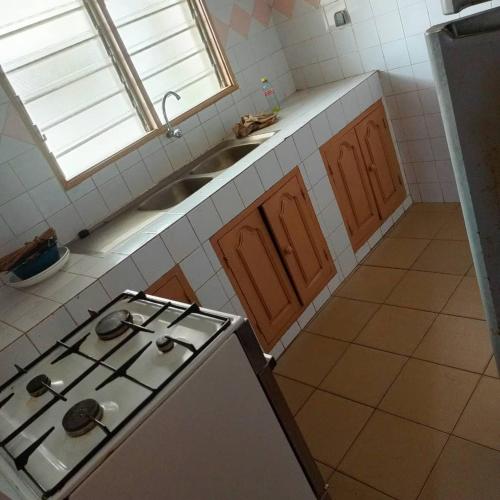a kitchen with a stove and a sink at Villa meublée Arconville 2 Chambre in Abomey-Calavi