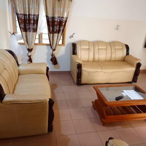 Sala de estar con 2 sofás y mesa de centro en Villa meublée Arconville 2 Chambre en Abomey-Calavi