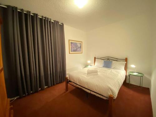 una camera da letto con un letto e una finestra con tende di Quiet 2BR Apartment with Garden views in Griffith - Hosted by CanStay a Kingston 
