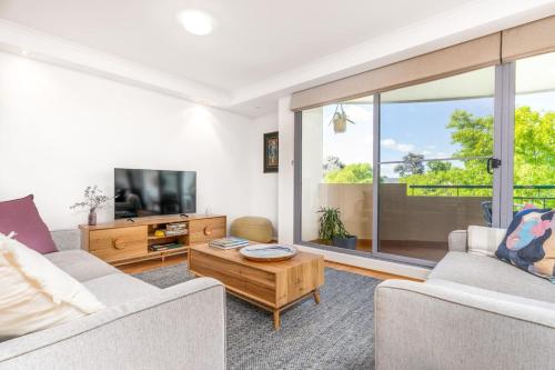 a living room with a couch and a tv at 2BR 2BA Apt with Dedicated Workspace and Free parking - Hosted by CanStay in Kingston