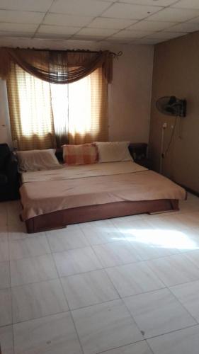 a large bed in a bedroom with a window at Magodo Treat in Lagos