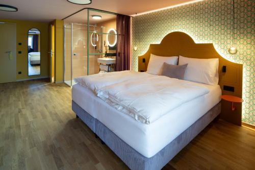 a bedroom with a large white bed and a bathroom at Schwarzes Rössl in St. Wolfgang