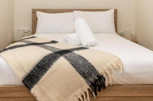 a bed with a black and white blanket and pillows at Charming Apt 1min to Marketplace Gungahlin - Hosted by CanStay in Harrison