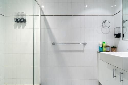 a white bathroom with a shower and a sink at Charming Apt 1min to Marketplace Gungahlin - Hosted by CanStay in Harrison