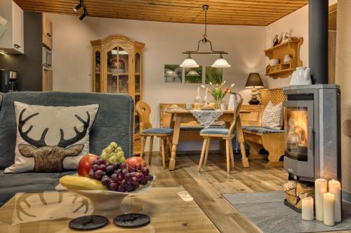 a living room with a couch and a table with a bowl of fruit at Wohlfühl-Ferienwohnungen Kirchberger in Bodenmais