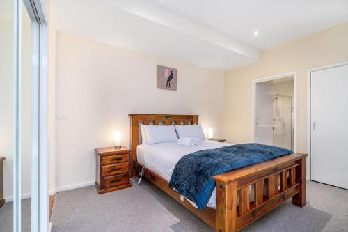 - une chambre avec un lit en bois et un miroir dans l'établissement Absolutely spacious APT unit between ANU and City - Hosted by CanStay, à Canberra