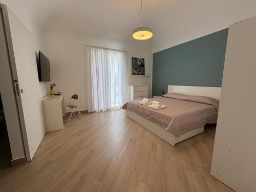 1 dormitorio con 1 cama y suelo de madera en Casa AnnaBella, en Trapani