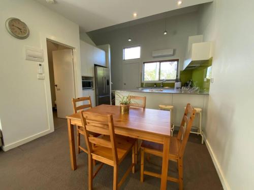 a kitchen and dining room with a wooden table and chairs at Cosy Work From Home Townhouse 10 Mins From City - Hosted by CanStay in Canberra