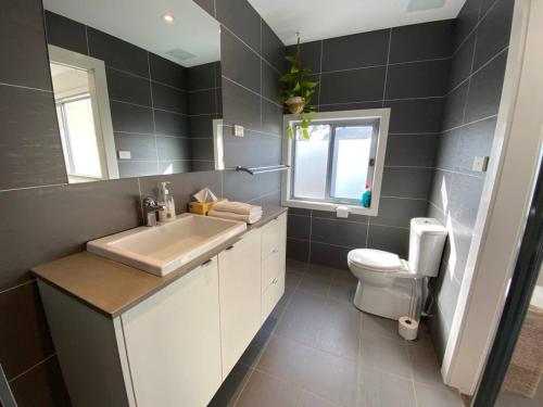a bathroom with a sink and a toilet and a window at Cosy Work From Home Townhouse 10 Mins From City - Hosted by CanStay in Canberra