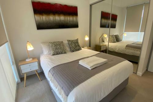 a bedroom with a large bed and a mirror at 2BR Light Filled and Cosy Apartment - Hosted by CanStay in Phillip