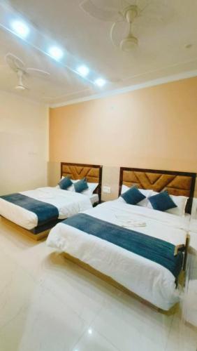 duas camas num quarto de hotel com almofadas azuis em Goroomgo Prakash Residency Varanasi Near Kashi Vishwanath Temple em Varanasi