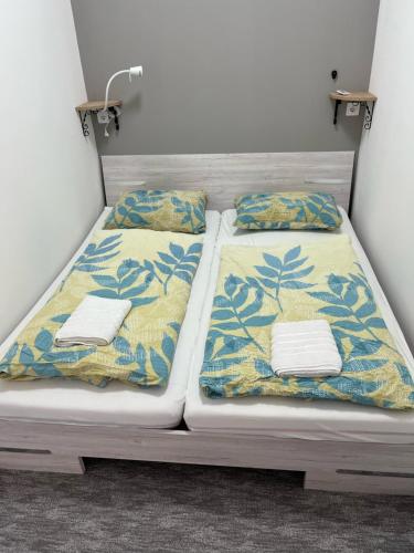 Dos camas en una habitación con toallas. en Centr00m Apartman, en Dunaföldvár