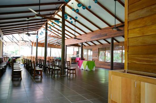 a large room with chairs and tables in a building at Pachira Lodge in Tortuguero