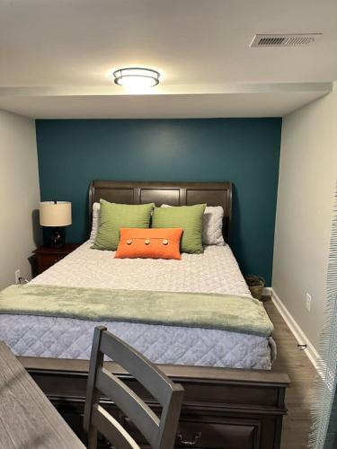 a bedroom with a bed with an orange pillow on it at Sardis Forest Gem, 2BR, Fast WiFi, Free Parking in Charlotte