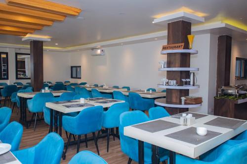 a dining room with blue chairs and tables at Hotel Pokhara Village & SPA in Pokhara