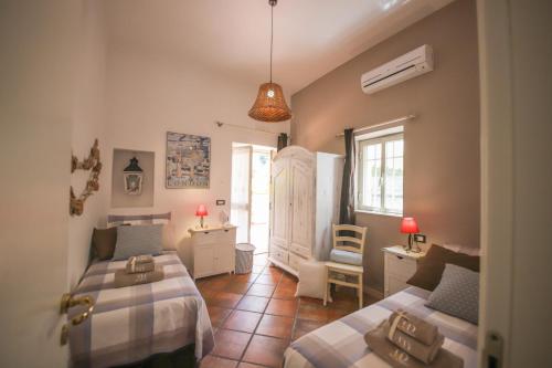 een slaapkamer met 2 bedden, een bureau en een stoel bij Trulli&Dimore - Villa Marinesca in Polignano a Mare