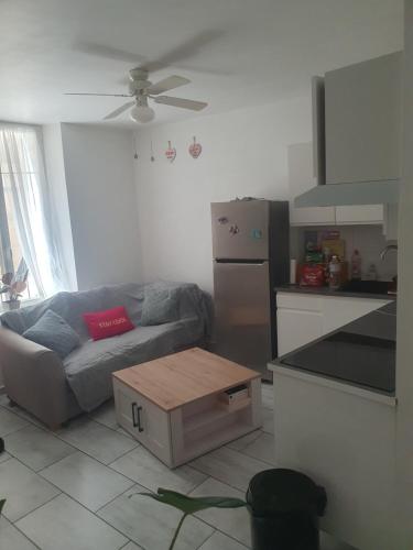 un salon avec un canapé et une cuisine dans l'établissement Bel appartement à deux minutes du vieux port, à La Ciotat