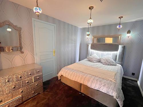 une chambre avec un lit, une commode et un miroir dans l'établissement Penthouse Luxury Appartement SPA Sauna, à Garches