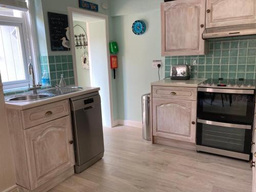 a kitchen with a sink and a stove top oven at Gulls Wing Apartment in Ventnor
