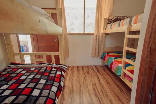 um quarto com 2 beliches e uma janela em Backpackers-balcones-river-lodge em Baños