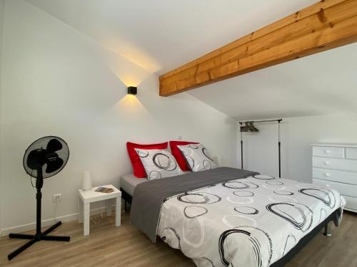 a bedroom with a bed with red pillows at DUPLEX de 40 m2 près d'une rivière in Saint Alban Auriolles