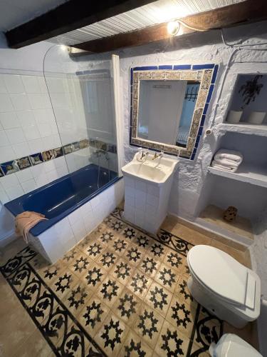a bathroom with a toilet and a sink and a tub at Cortijo El Berrocal in Cazalla de la Sierra