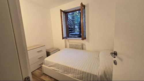 een kleine slaapkamer met een bed en een raam bij Villetta del Prato in Roccaraso