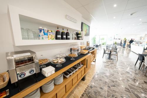 a restaurant with a counter with food on it at Hotel Auditorium in Bari