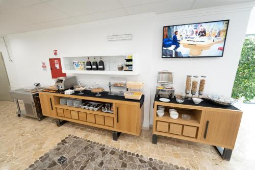 a coffee shop with two tables and a tv on the wall at Hotel Auditorium in Bari