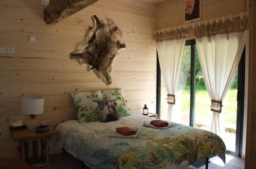 um quarto com uma cama com uma cabeça de árvore na parede em L'orée du bois gaubau em Saint-Georges-sur-Layon