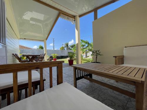 porche con mesa y sillas de madera en Villa TiCazMimose en Saint-André