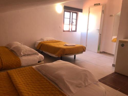 um quarto com duas camas e uma janela em NN Guest House em Coimbra