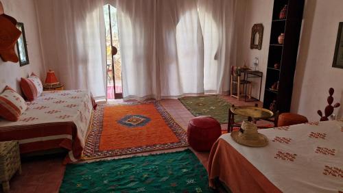 a bedroom with two beds and a window at Les Trois Paons in Taroudant
