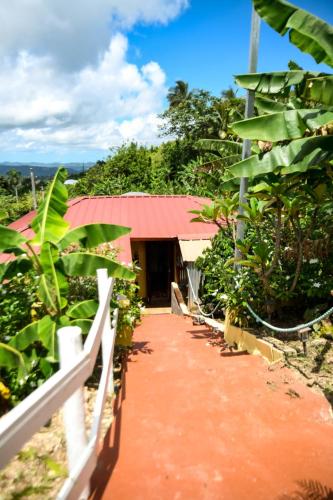 a walkway leading to a building with a red roof at Casa de Campo Vista Hermosa in Lares